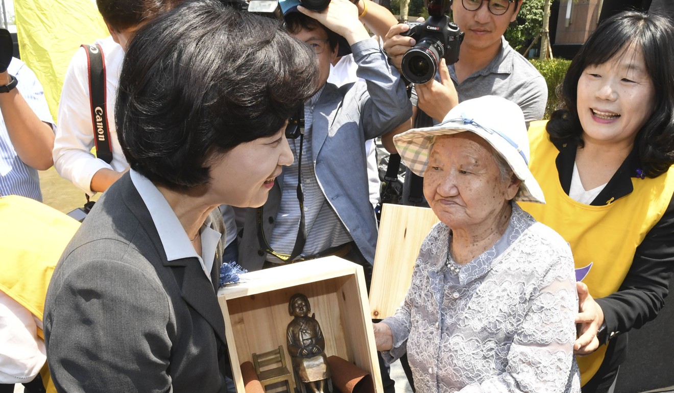 Choo Mi-ae (left), leader of the ruling Democratic Party of Korea, receives from a former ‘comfort woman’ a miniature statue symbolising women who were forced into wartime brothels for the Japanese military. Photo: Kyodo