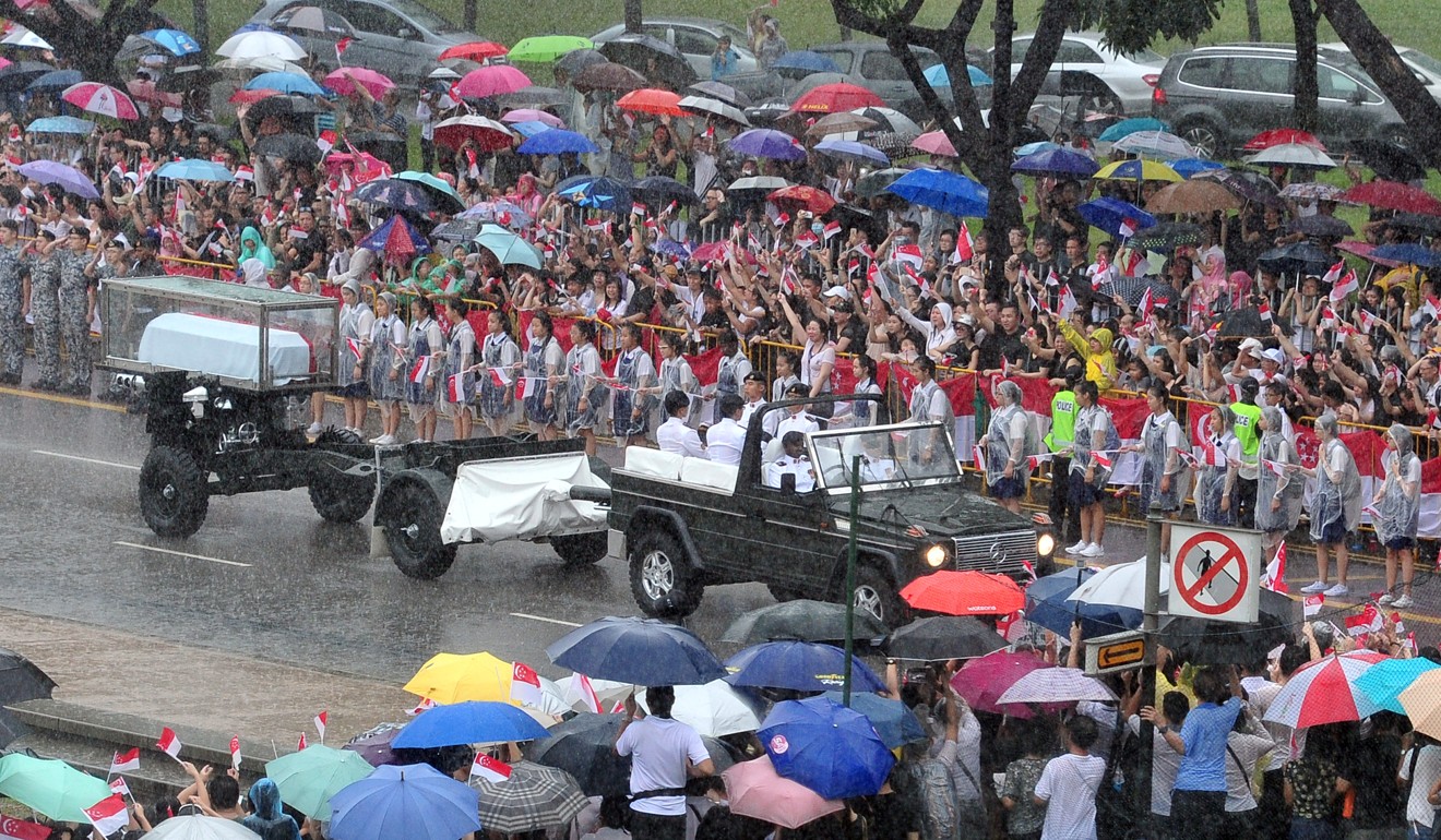 Thousands line the streets amid heavy downpours as a military gun carriage carrying the coffin of Singapore’s founding father Lee Kuan Yew passes in a state funeral procession, on March 29, 2015. Photo: Xinhua