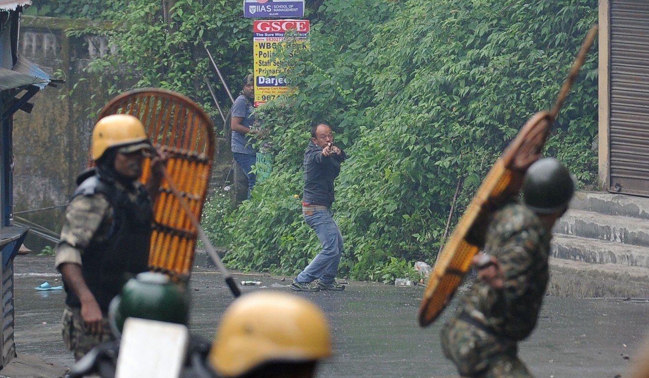 A supporter of the Gorkha Janmukti Morcha group fires a slingshot during clashes with Indian security forces in Darjeeling. Photo: AFP