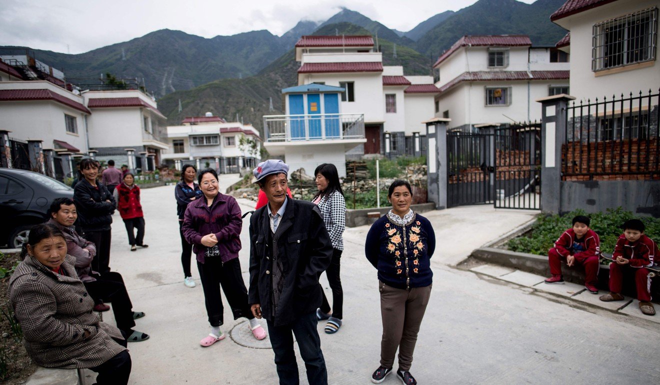 Villagers in front of their new houses in a new village near Lianghekou, Sichuan province, after they were relocated due to the construction of the Lianghekou dam. Photo: AFP