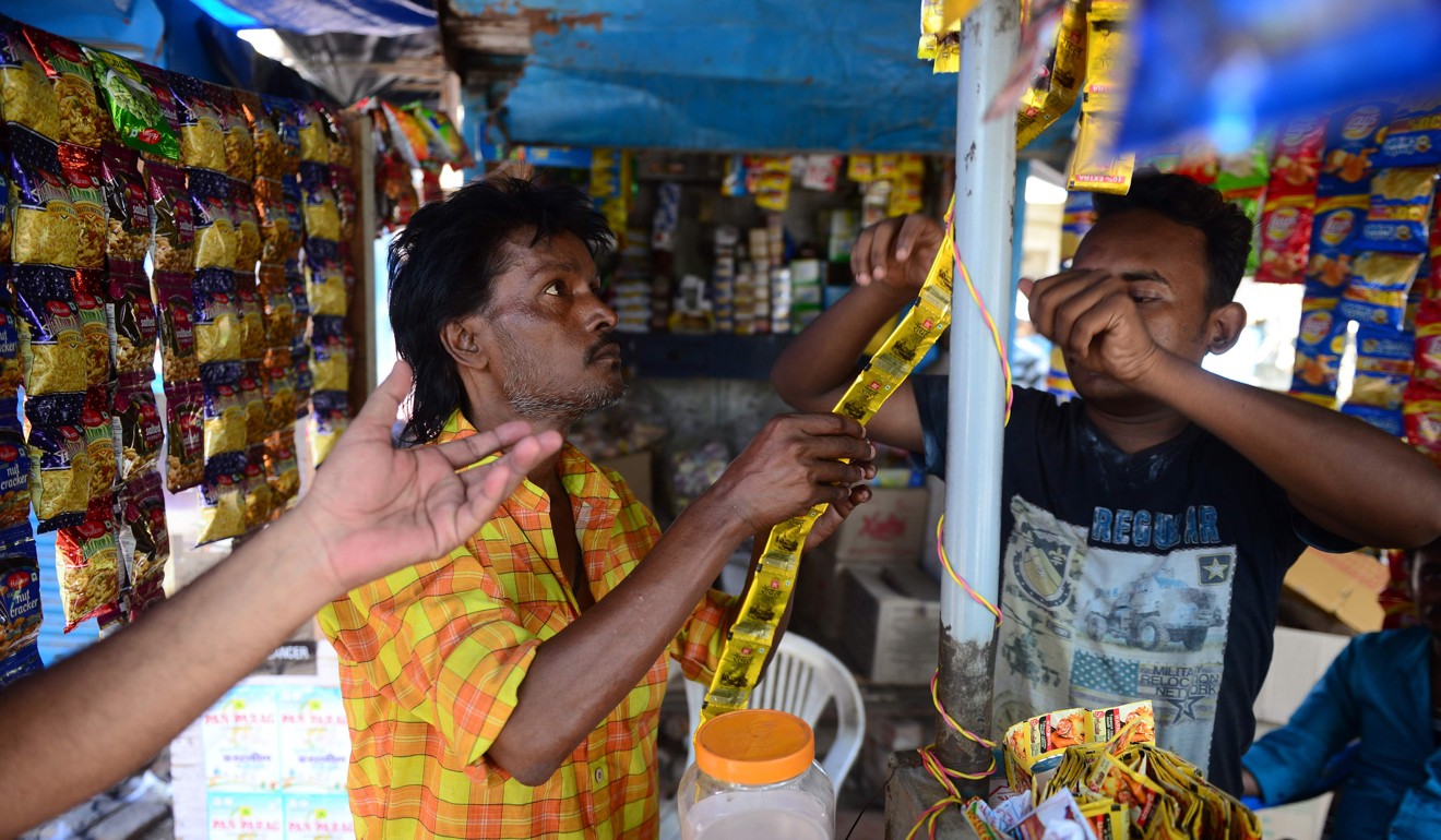 An Indian customer buys Gutkha Pan masala at a shop in Allahabad.The long-awaited goods and services tax is rolling out, even as businesses complain they are ill-prepared for it. Photo: AFP