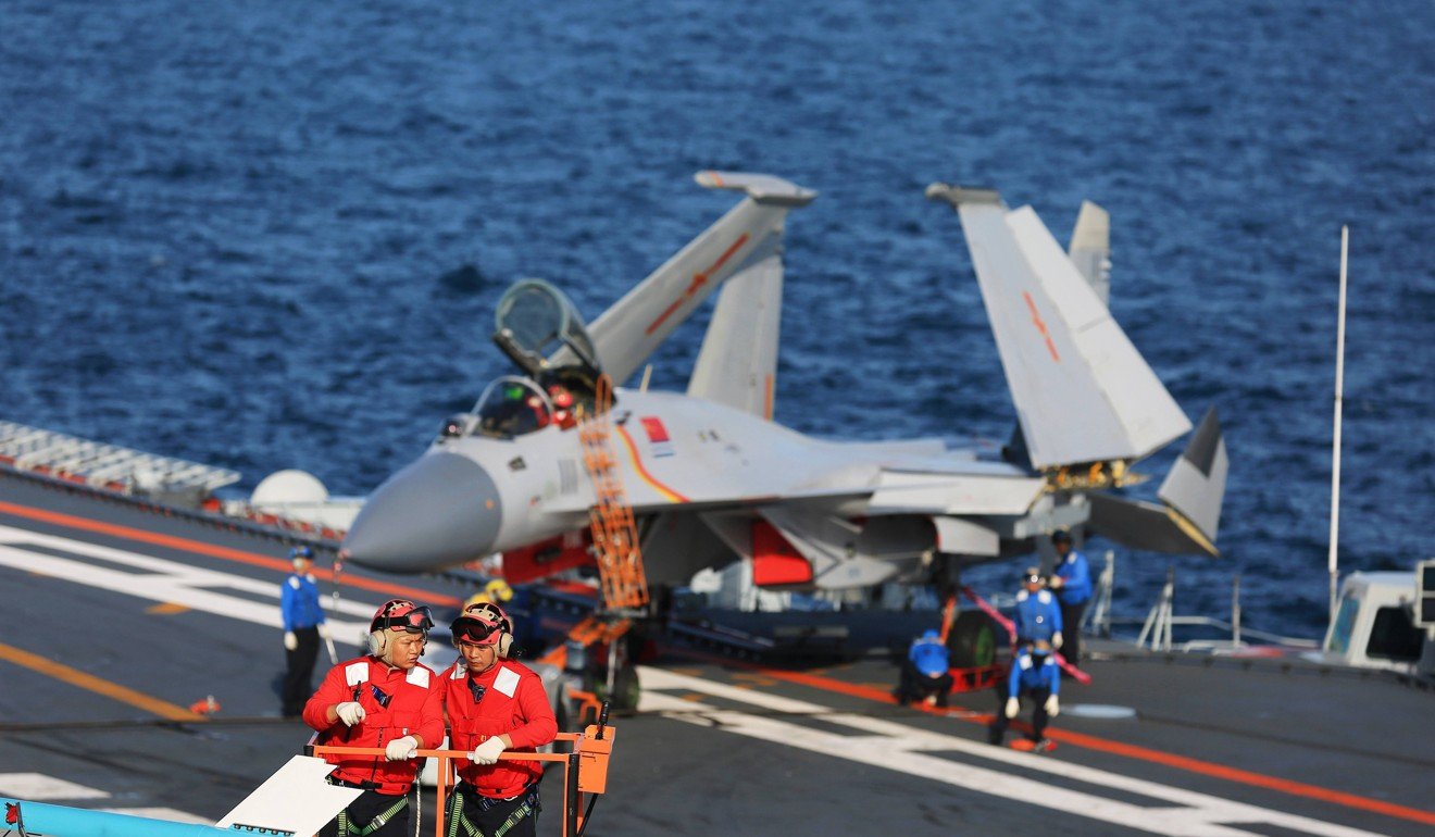 A J-15 fighter jet is inspected aboard the Liaoning. Photo: Xinhua