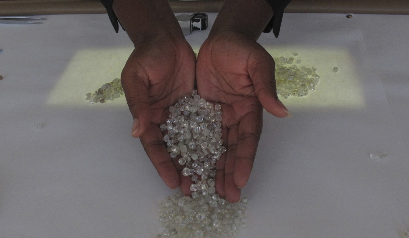 A fistful of diamonds held by Dina Muhimba as she sorts gemstones at the Namibia Diamond Trading Company in Windhoek, Namibia. Photo: AP