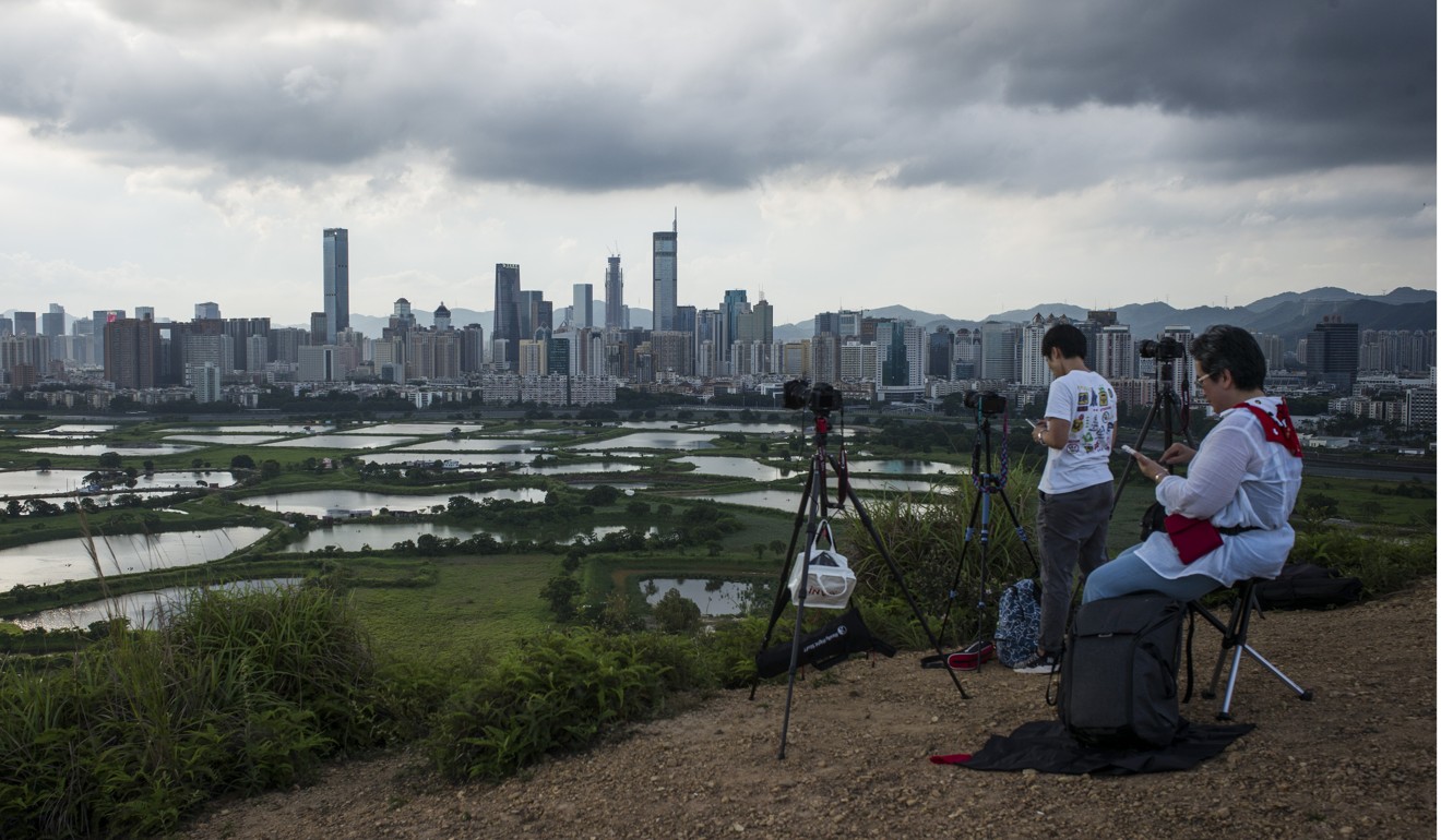 Photographers capture the Shenzhen skyline from the Ma Tso Lung district of Hong Kong. Two decades after reunification, legal cooperation in criminal matters between Hong Kong and the rest of China has not progressed at all, and this must be rectified. Photo: Bloomberg