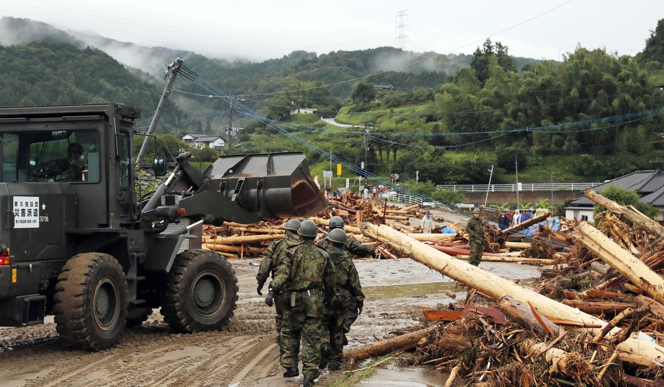 Members of Japan Self-Defence Forces debris blocking a road in Asakura. Photo: Kyodo/AP