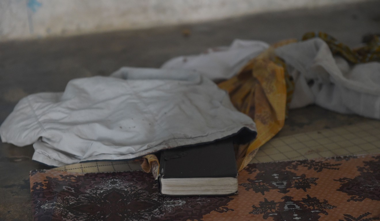 A Bible lies on the floor half covered by blood stained clothes of worshippers killed by shadowy gang dubbed the Badoo in the Crystal Church of God at Owode Onirin in Lagos. Photo: AFP