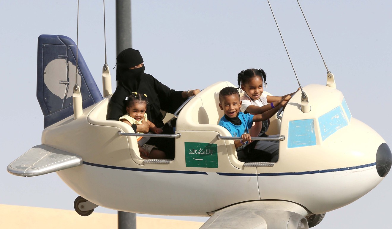 A Saudi family enjoys a mini-plane amusement ride at King Abdulaziz Park in Riyadh, Saudi Arabia, on the last day of Eid al-fitr, on June 27, 2017. Eid al-Fitr marks the end of the Ramadan fasting period. Photo: EPA
