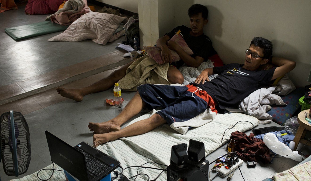 Samart Senasuk (above, right) watches a film with another former Thai fishing boat slave in the port of Mahachai. Photo: Antolin Avezuela