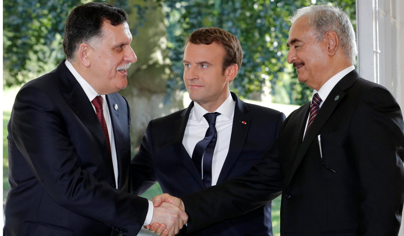 French President Emmanuel Macron stands between Libyan Prime Minister Fayez al-Sarraj (left), and General Khalifa Haftar (right), commander in the Libyan National Army, who shake hands after talks over a political deal to help end Libya’s crisis in La Celle-Saint-Cloud near Paris on Tuesday. Photo: Reuters
