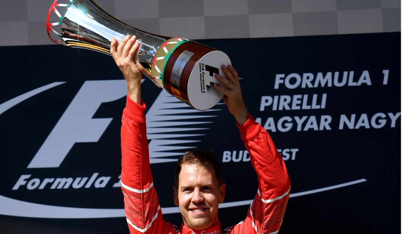 Ferrari's German driver Sebastian Vettel celebrates on the podium. Photo: AFP