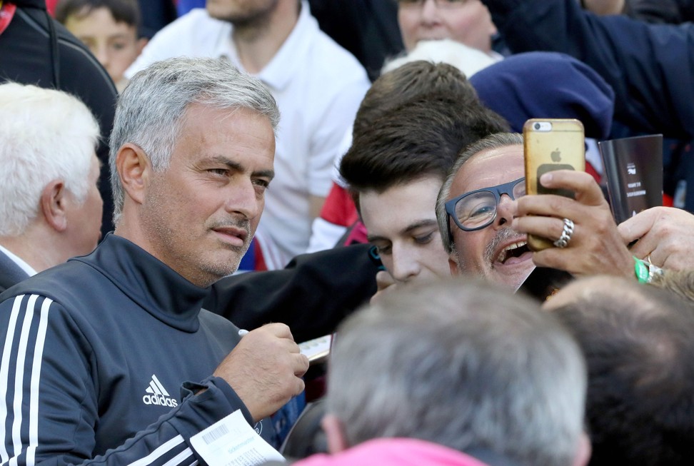 United manager Jose Mourinho poses with a supporter. Photo: AFP