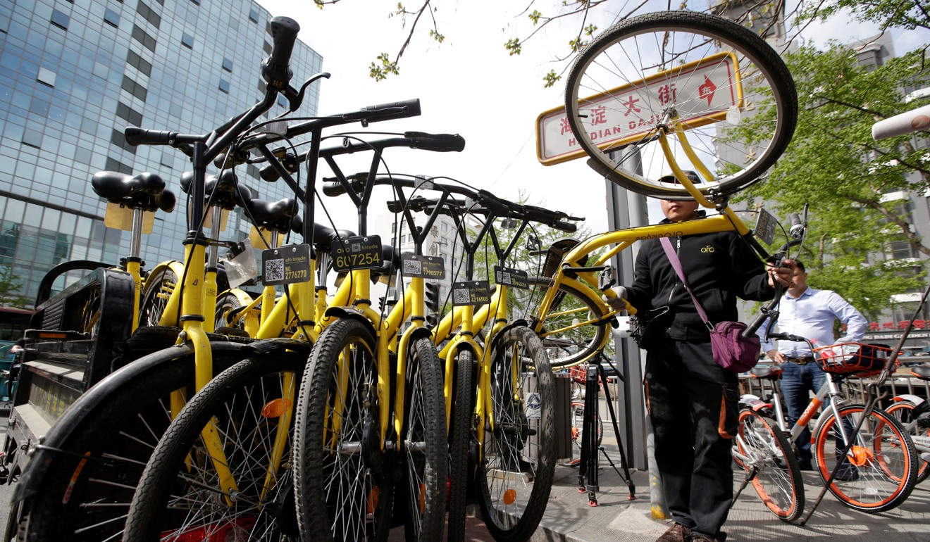 A member of staff collects Ofo bikes in the centre of Beijing. Photo: Reuters