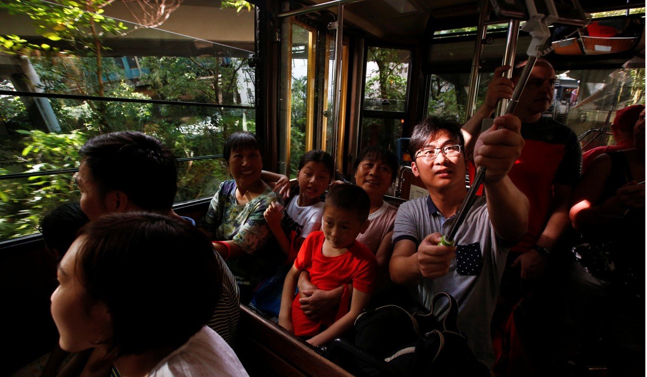A Chinese tourist takes a selfie during a Peak Tram ride in Hong Kong. A study by the Brookings Institution estimates that 88 per cent of the next billion middle-class people are likely to be in the Asia-Pacific region. Photo: Reuters