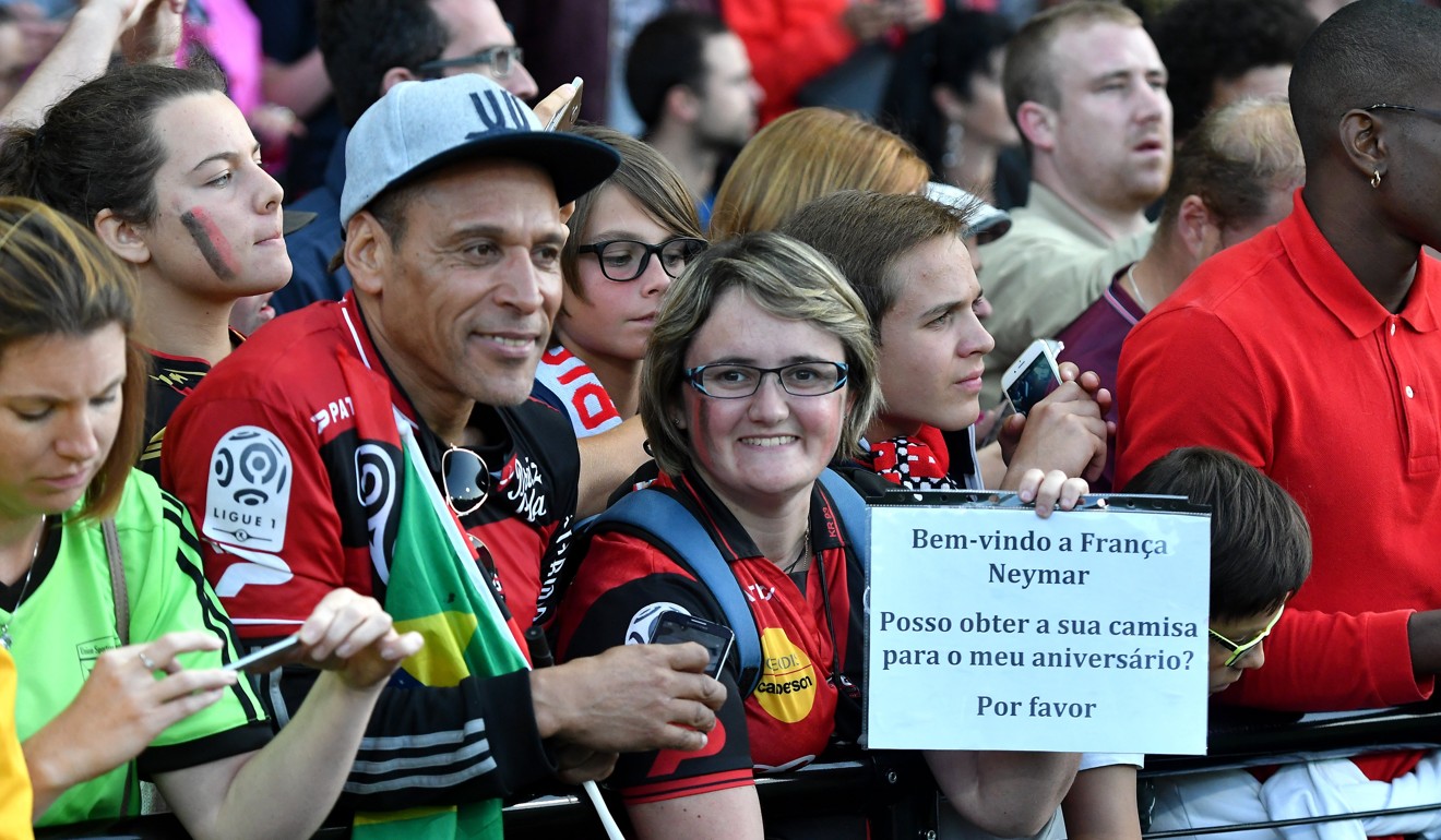 A Guingamp supporter holds a sign reading ‘Welcome in France Neymar – may I get your shirt as my birthday present, please’. Photo: EPA