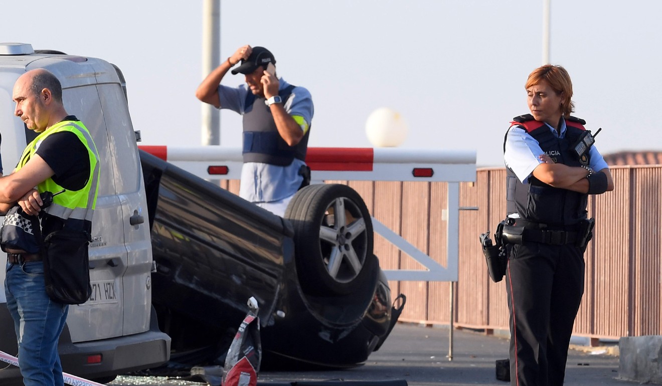 A policeman stands by a car involved in a terrorist attack in Cambrils. Photo: AFP