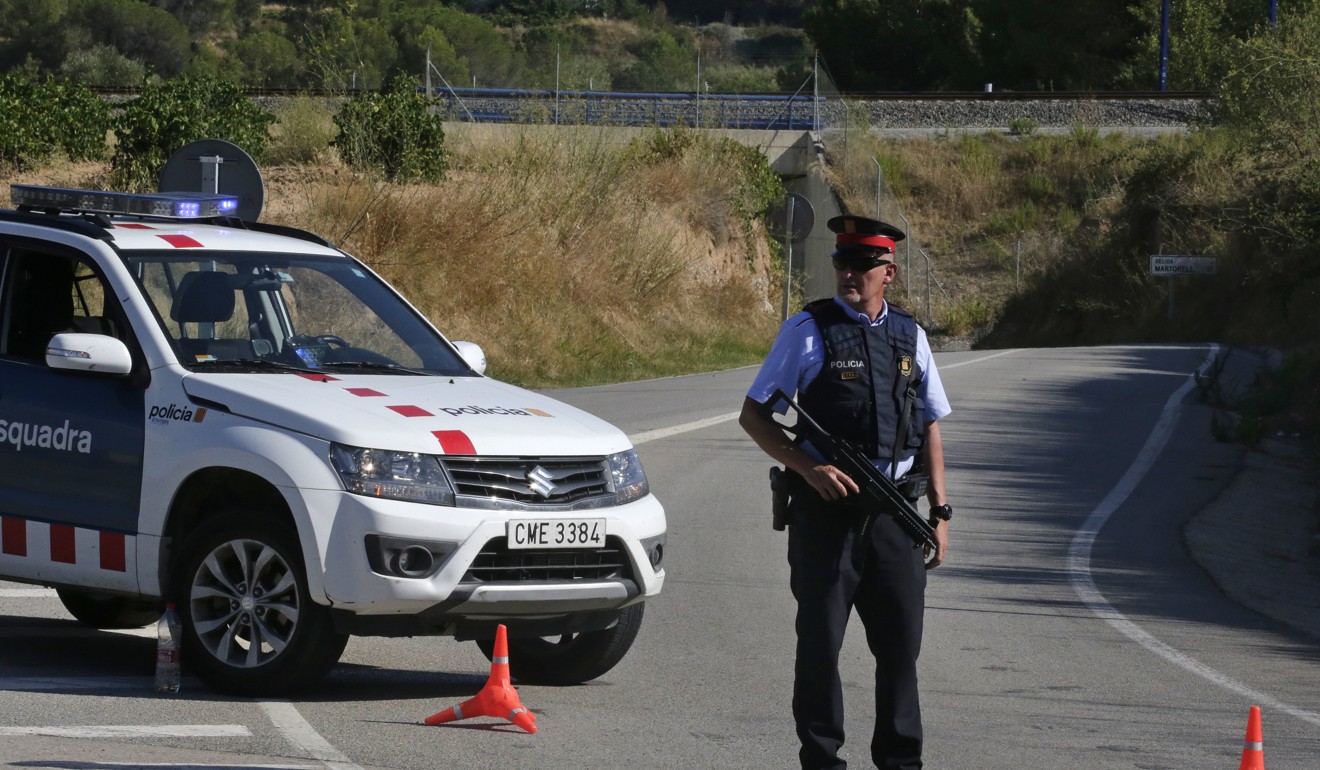 An armed police officer standa guard near Subirats, Spain, Monday, August 21, 2017. A police operation was underway Monday in an area west of Barcelona, and a Spanish newspaper reports that the fugitive in the city's van attack has been tracked in the area. Photo: AP
