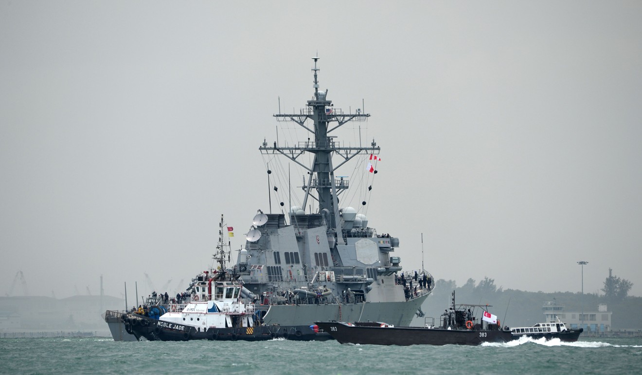 The guided-missile destroyer USS John S. McCain guided by a tugboat. Photo: AFP