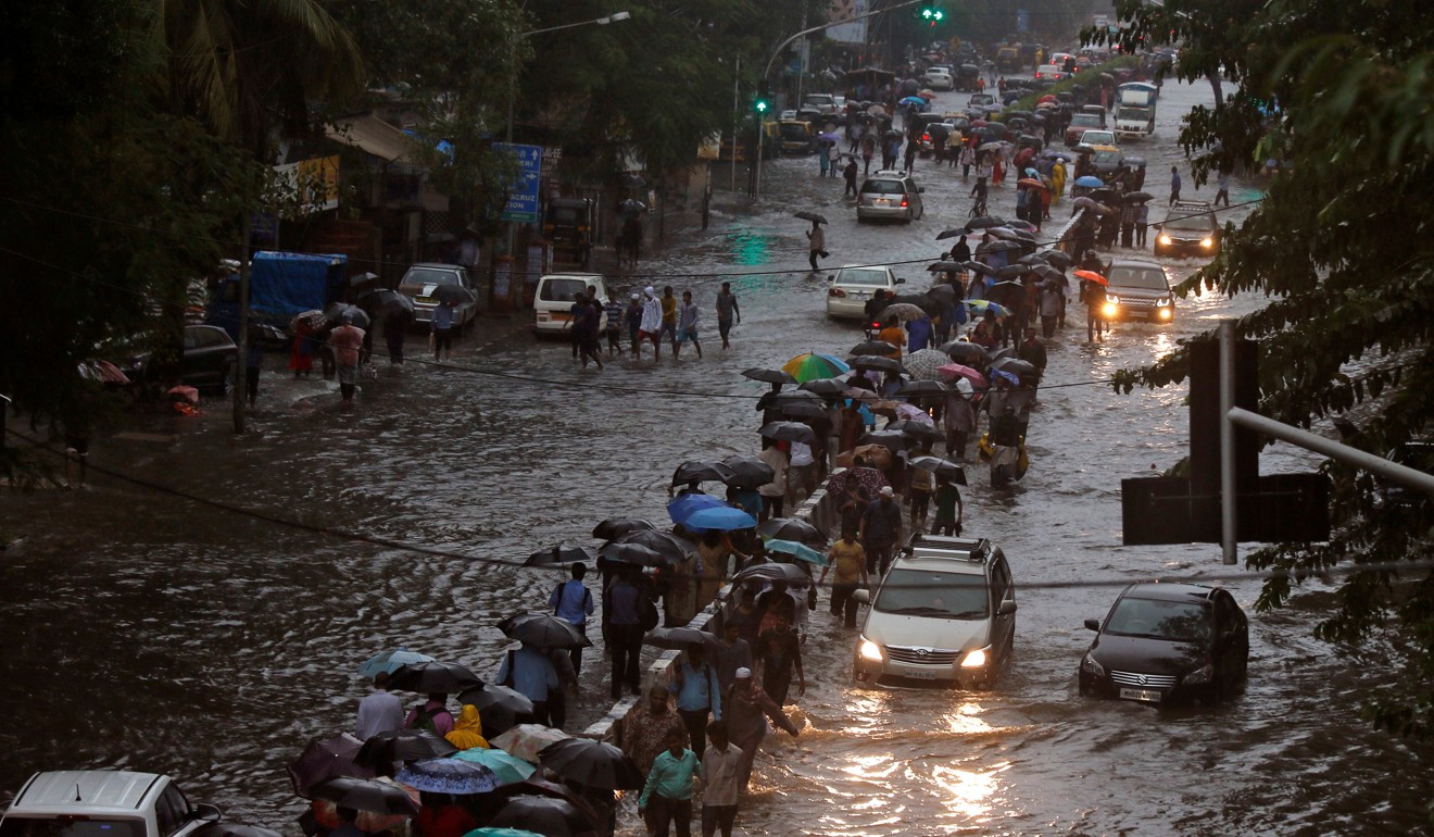 Commuters walk through waterlogged roads after heavy rain in Mumbai, India. Photo: Reuters