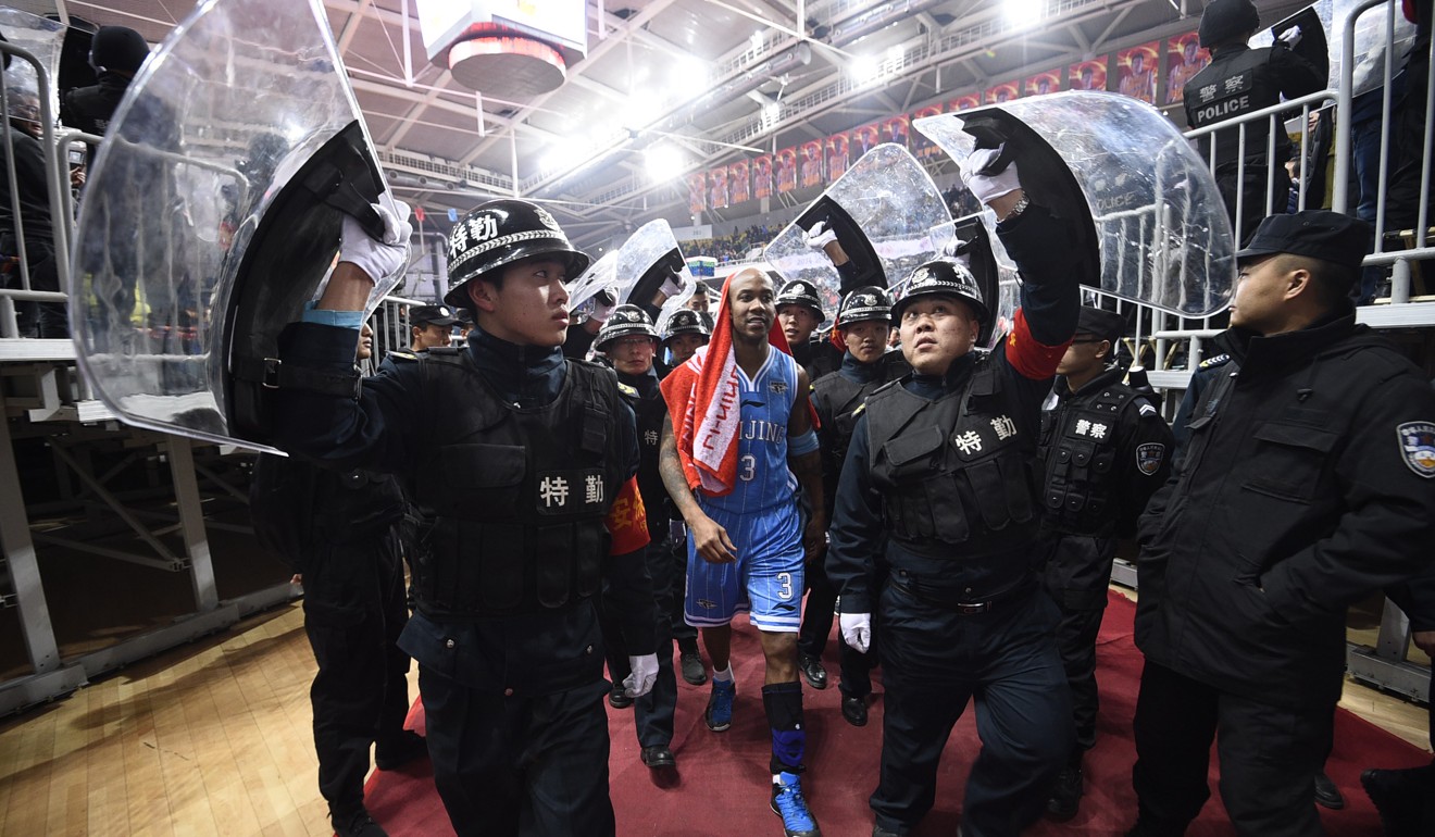 Chinese security guards hold up shields to protect Stephon Marbury during a Chinese Basketball Association match between Beijing Ducks and Shanxi Dragons. Photo: AP