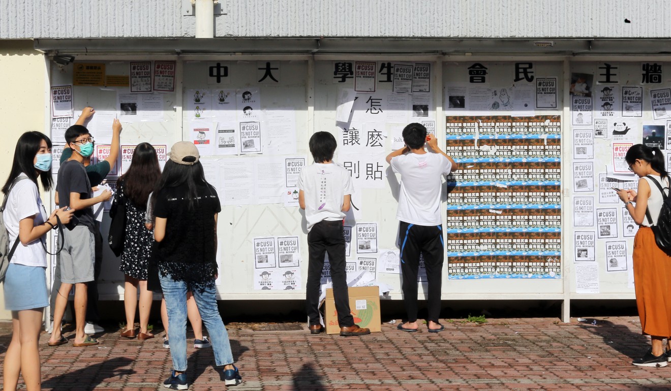 Students put posters on the wall at Chinese University. Photo: Dickson Lee