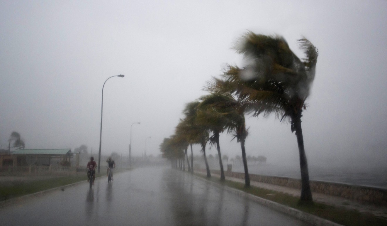 Bicyclists ride along the seawall in wind and rain brought on by Hurricane Irma, in Caibarien, Cuba. Photo: AP