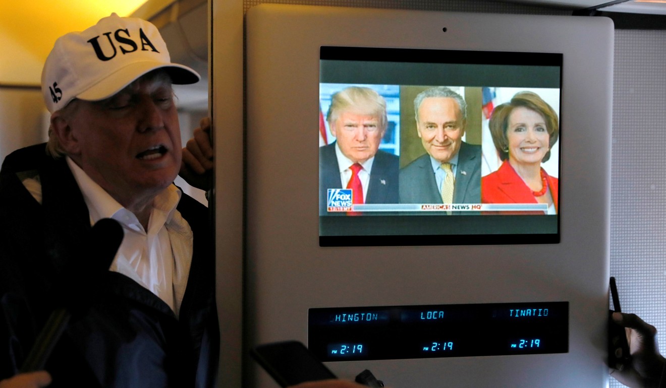 President Donald Trump on Air Force One as a news report plays about his relationship with Senate Minority Leader Charles Schumer and House Minority Leader Nancy Pelosi. Photo: Reuters
