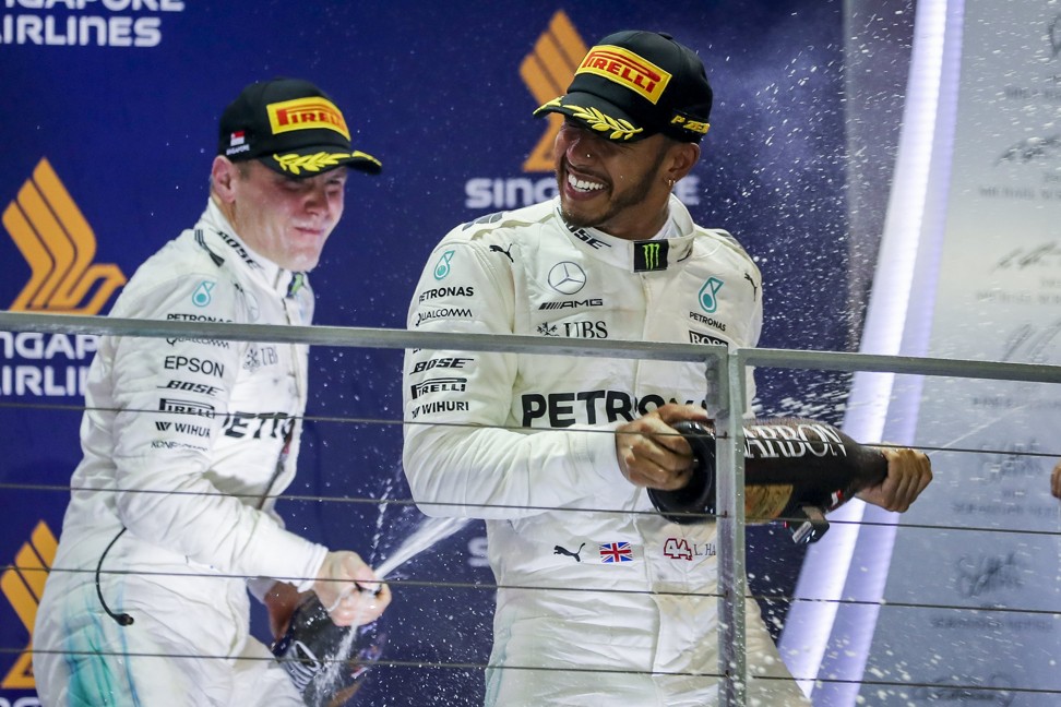 Hamilton and teammate Valtteri Bottas of Mercedes celebrate with champagne. Photo: EPA