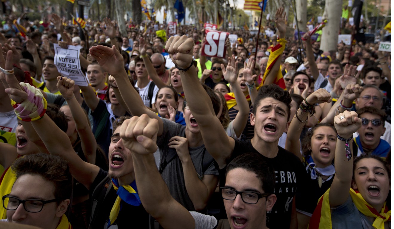 People gesture and shout slogans during a protest in Barcelona on Thursday to demand the release of a dozen officials arrested in connection with a vote on independence that Spanish central authorities are challenging as illegal. Photo: AP