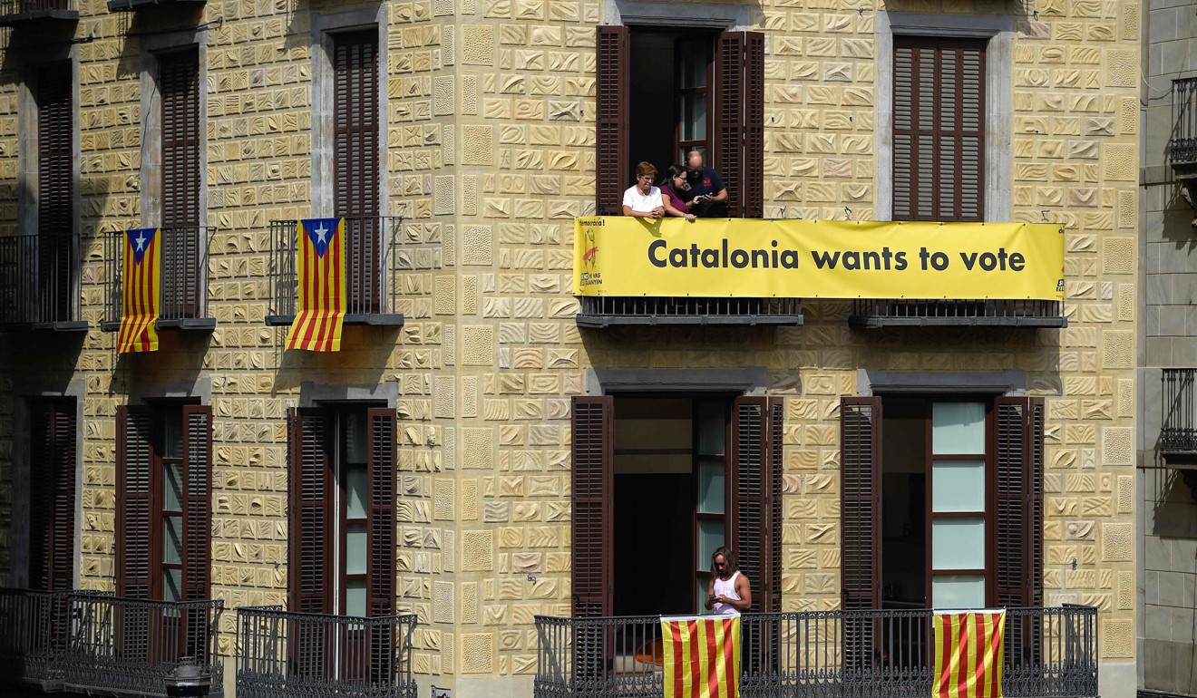 Catalan flags and a pro-referendum banner hang on a building in Sant Jaume square in Barcelona. Photo: AFP