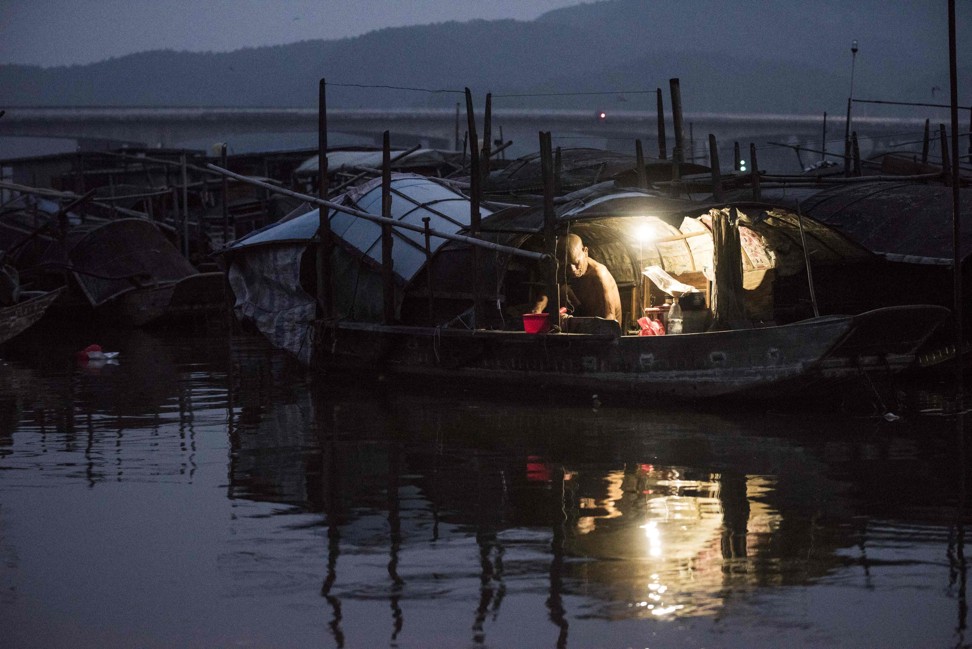 An elderly man from the Tanka community prepares to sleep in his boat. Photo: AFP