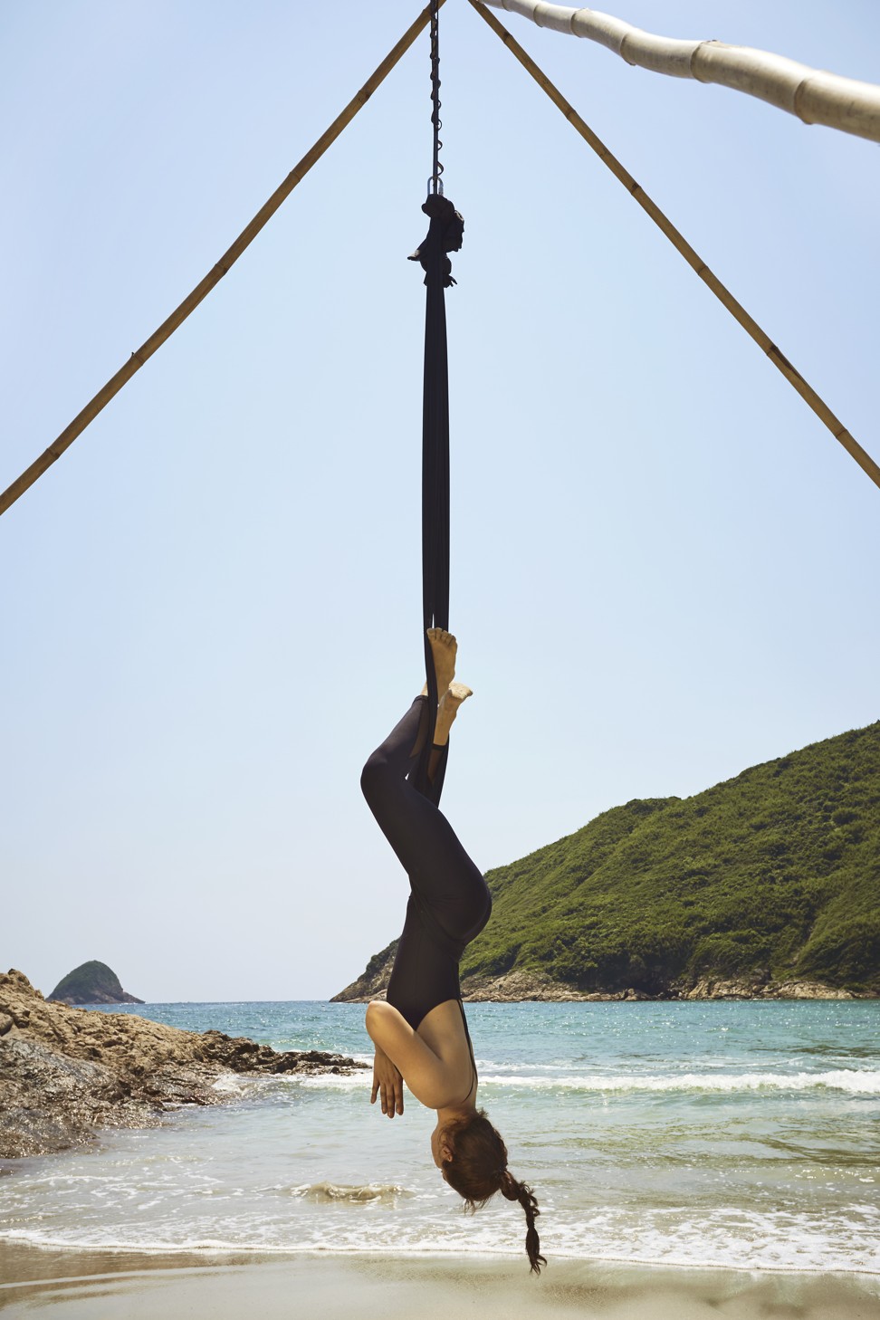 Milewicz demonstrates an inversion on her bamboo aerial yoga tripod. Photo: David Teng