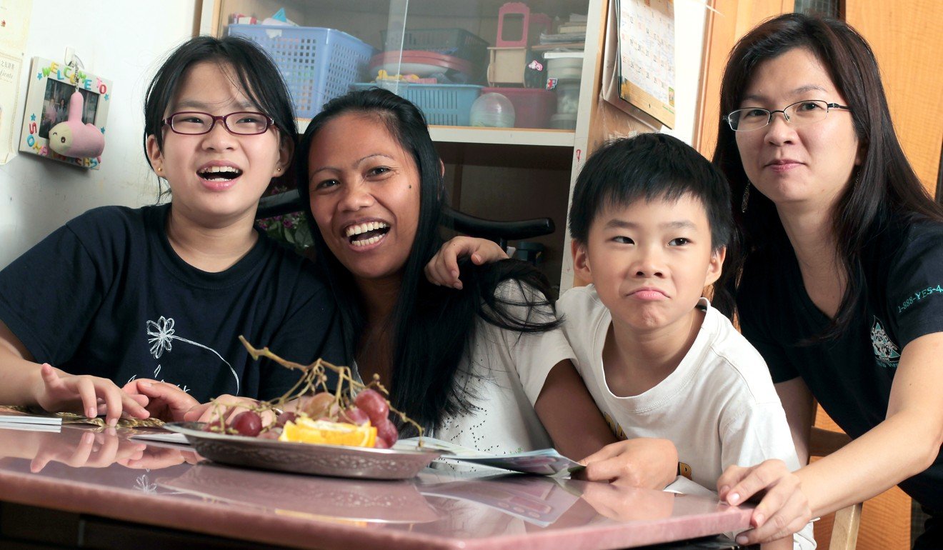Filipino maid Maricel Delan (second from left) with her employer Doris Lee (right) and her children Benji and Leni at their Ma On Shan home in 2011. By plugging the gaps in the care sector, migrant domestic workers are crucial for Hong Kong’s high-functioning economy. Photo: K.Y. Cheng