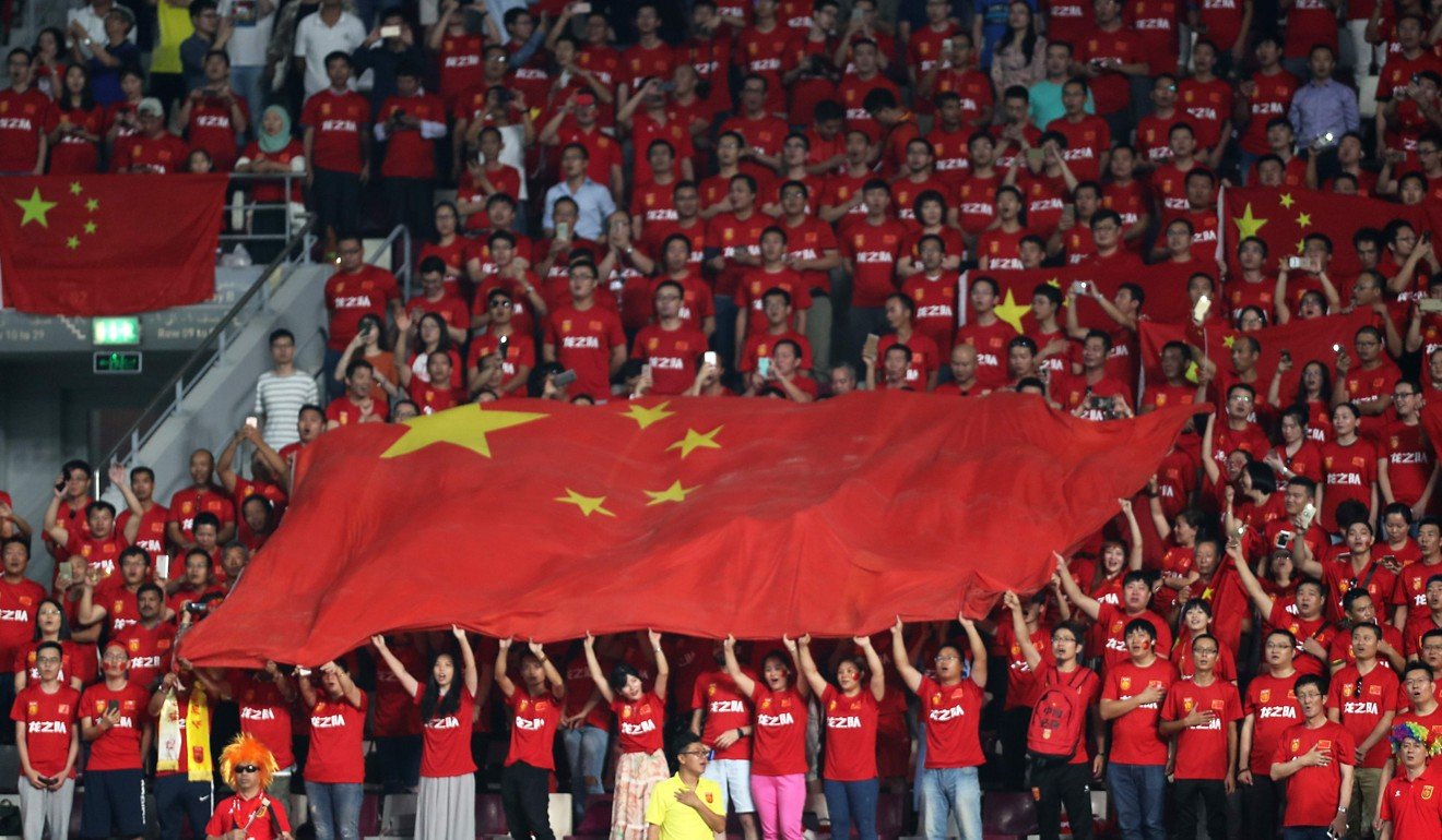 Chinese fans hold their national flag as they listen to their national anthem prior to the start of the FIFA World Cup 2018 qualification football match between Qatar and China at the Jassim Bin Hamed Stadium in Doha on September 5, 2017. Photo: AFP