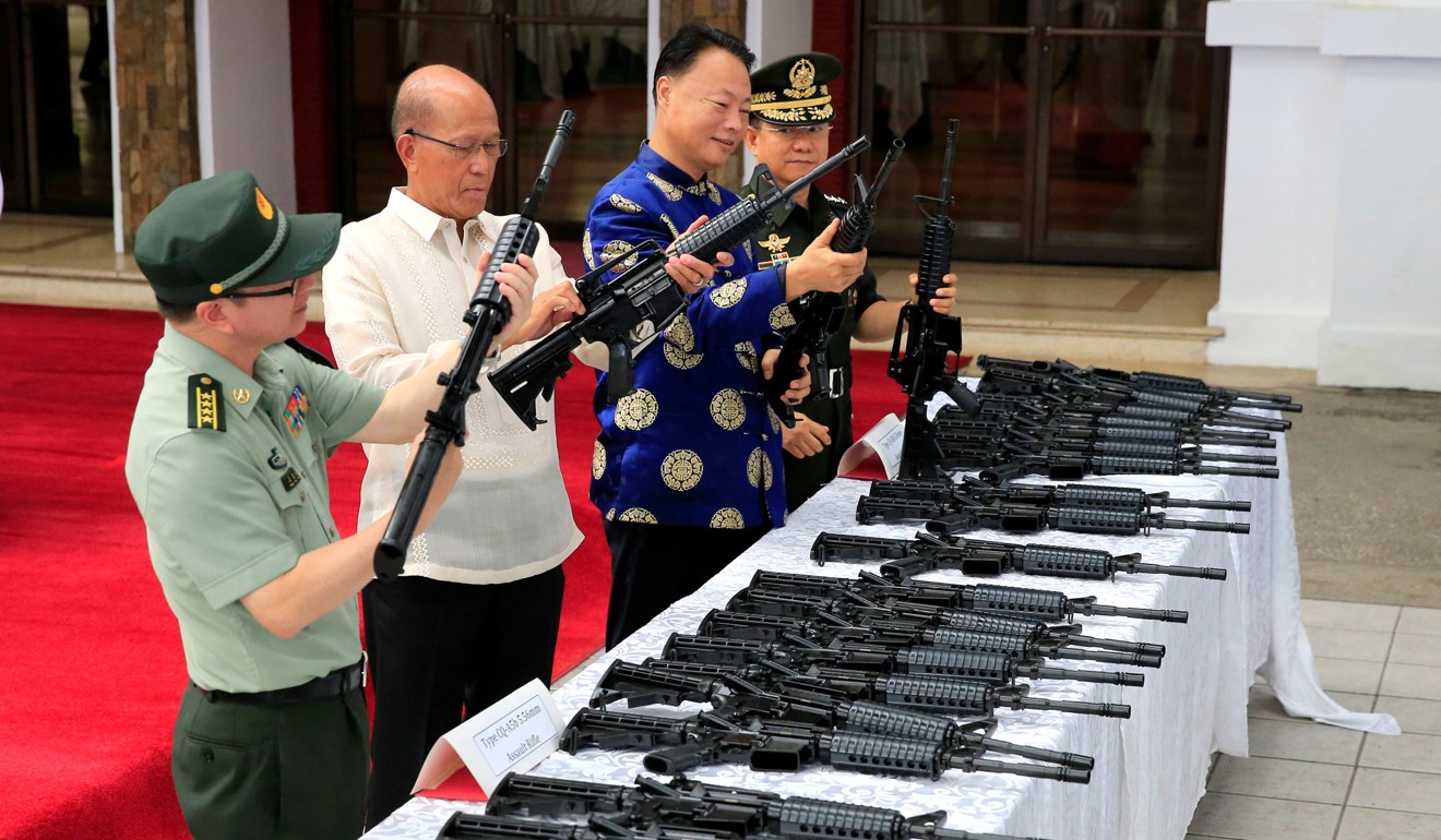Philippine Defence Secretary Delfin Lorenzana, China’s ambassador Zhao Jianhua and General Eduardo Ano inspect automatic rifles during the turnover ceremony of China's urgent military help to the Philippines on Thursday. Photo: Reuters