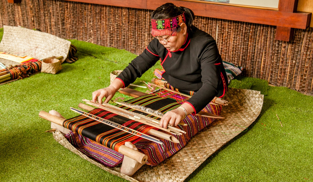 A Li woman shows her weaving skills at Betel Nut Heritage Park.