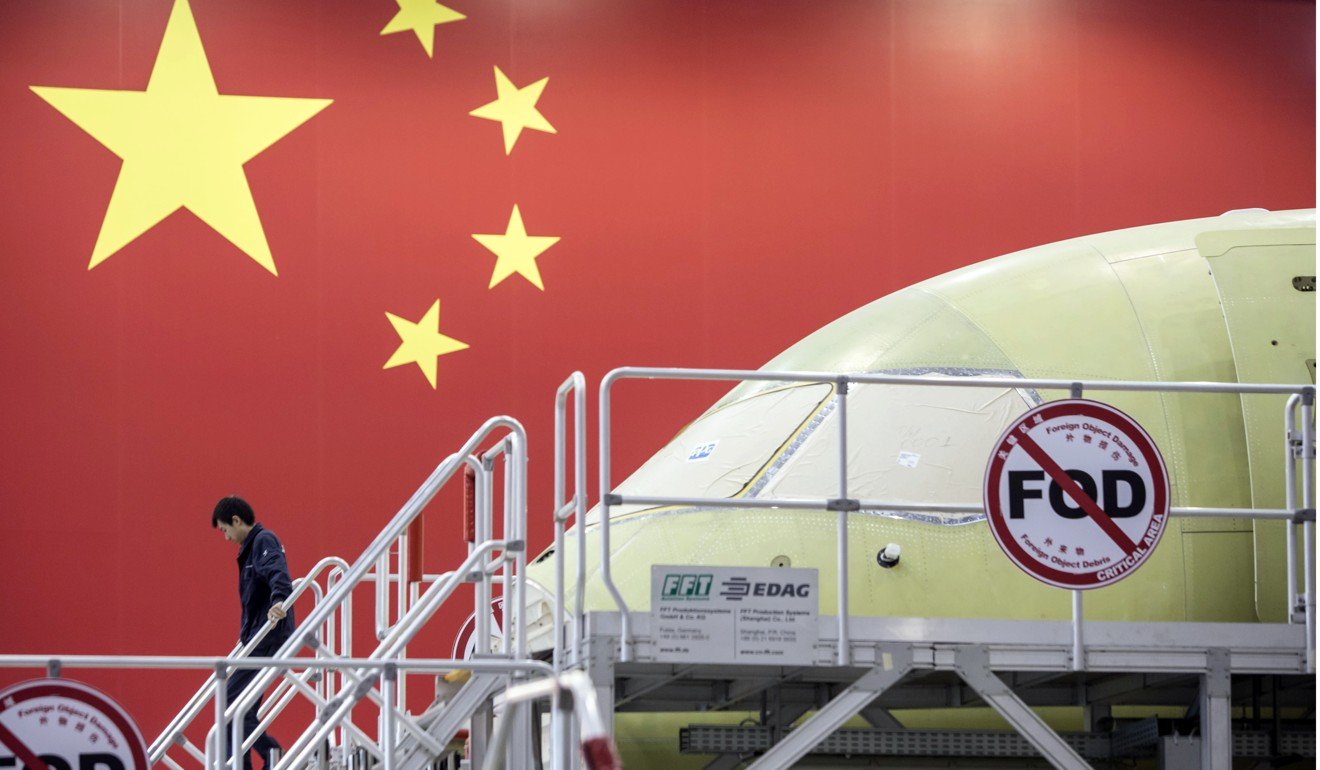 A Chinese flag adorns a wall behind a Comac C919, China's first modern passenger jet, under assembly in Shanghai in May. Photo: Bloomberg