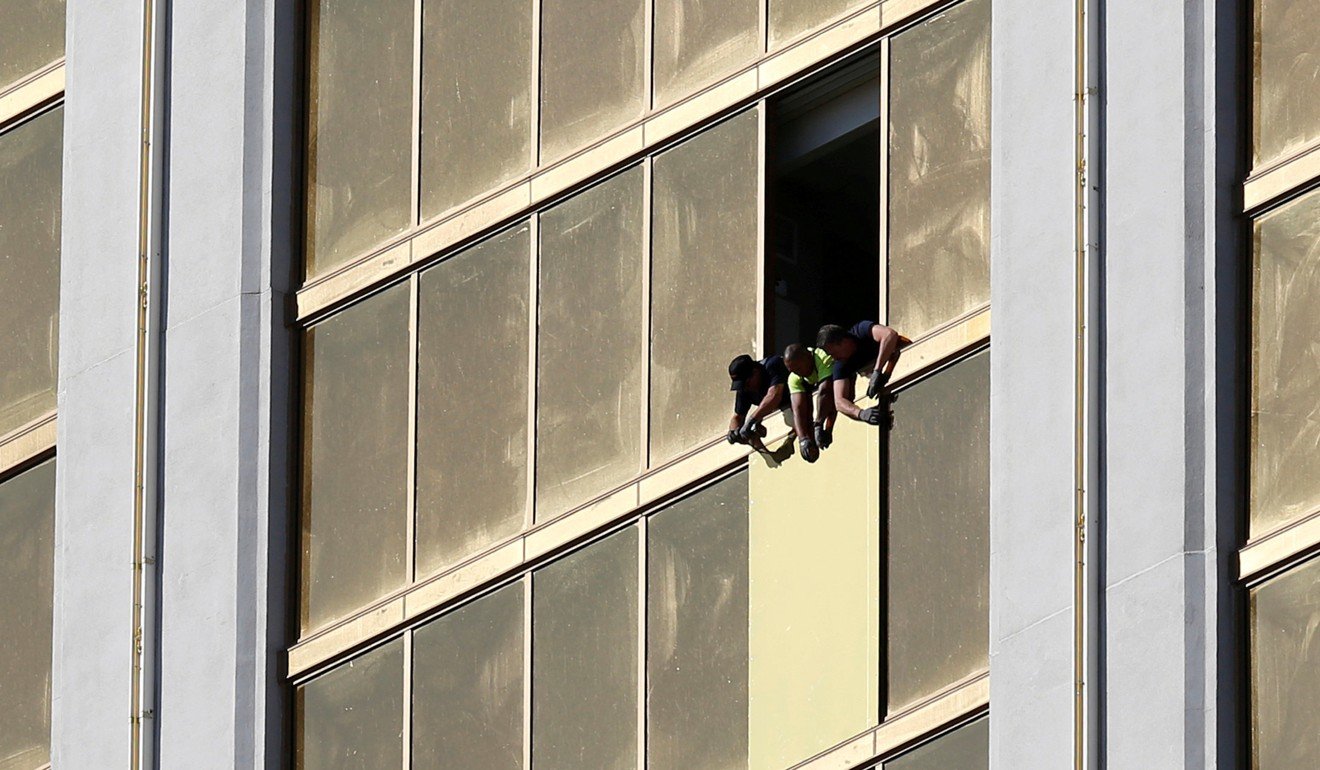 Workers board up a broken window at the Mandalay Bay hotel, where gunman Stephen Paddock conducted his mass shooting along the Las Vegas Strip. Photo: Reuters