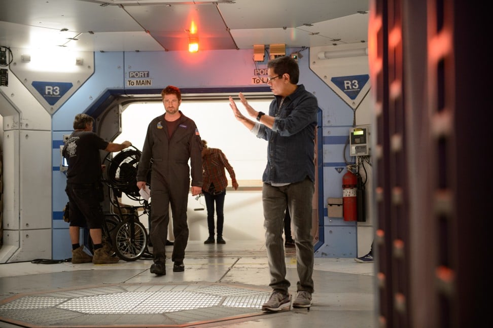 Butler (left) is talked through a scene by director Dean Devlin (right) on the set of Geostorm.
