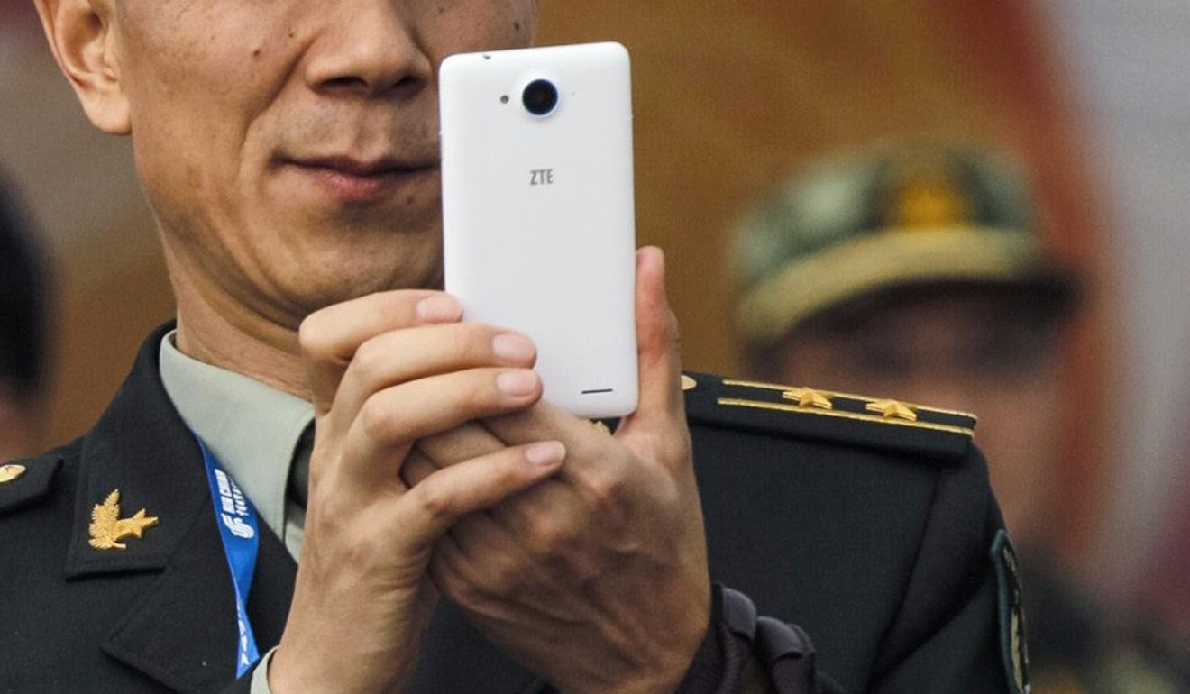 A file picture of a PLA officer using his mobile phone during an air show in Zhuhai. Phone: Reuters