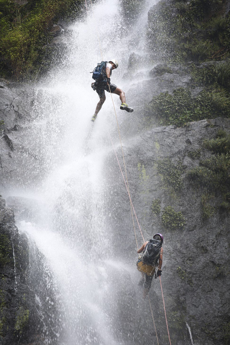 Mark Delecate (top) and his mother Janchai abseil down a waterfall in the New Territories. Photo: James Wendlinger