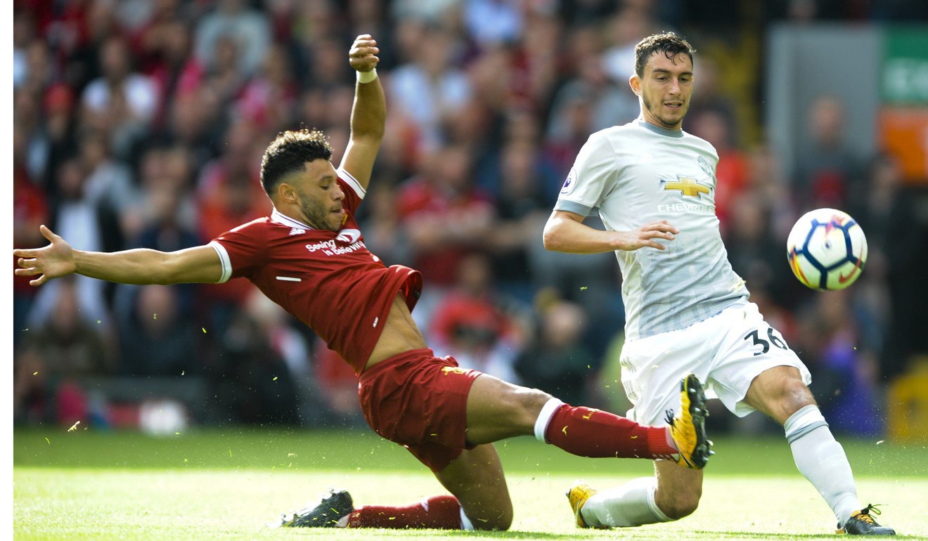 Liverpool's Alex Oxlade-Chamberlain and United's Matteo Darmian battle for the ball. Photo: AP