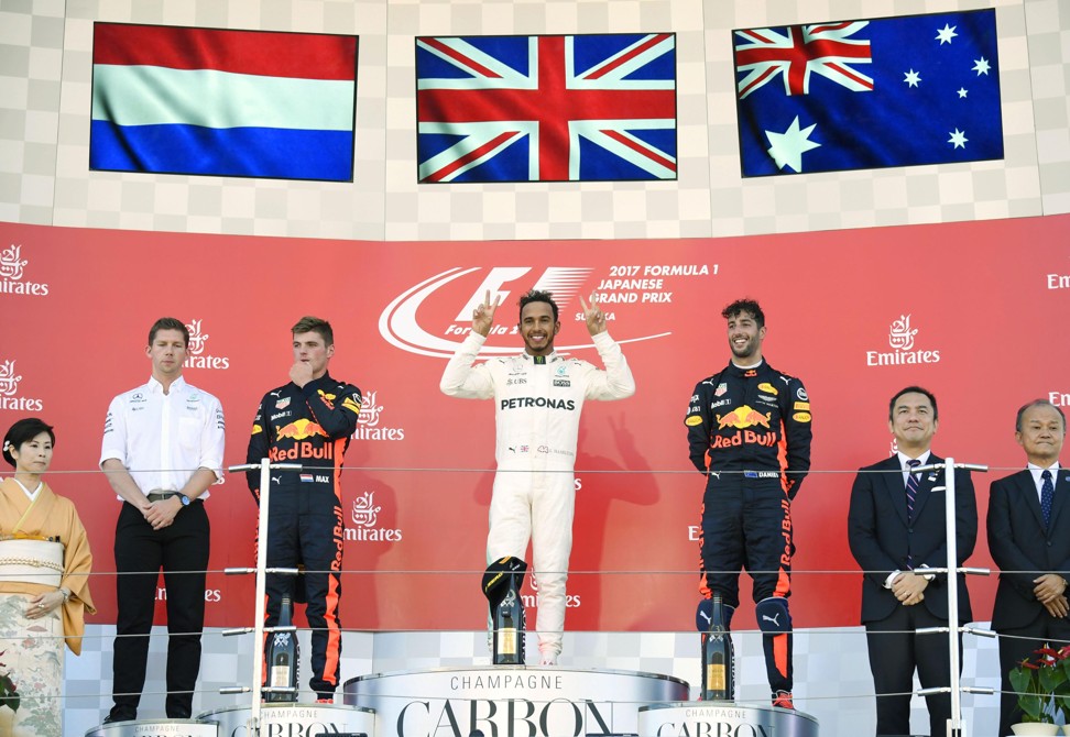 Hamilton (C) celebrates winning the Japanese Grand Prix alongside second-placed Max Verstappen (L) and third-placed Daniel Ricciardo. Photo: Kyodo