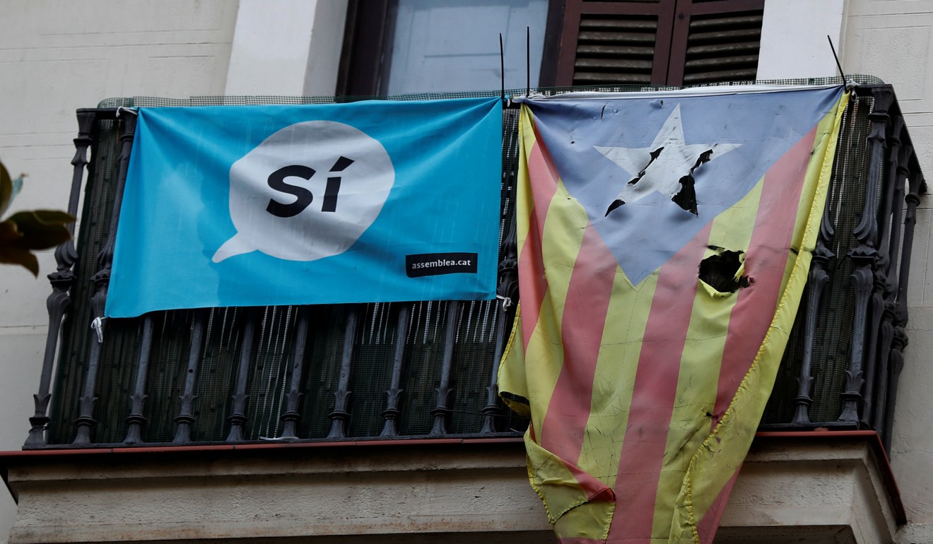 A damaged Estelada (Catalan flag of independence) hangs from a balcony in Barcelona. Photo: Reuters