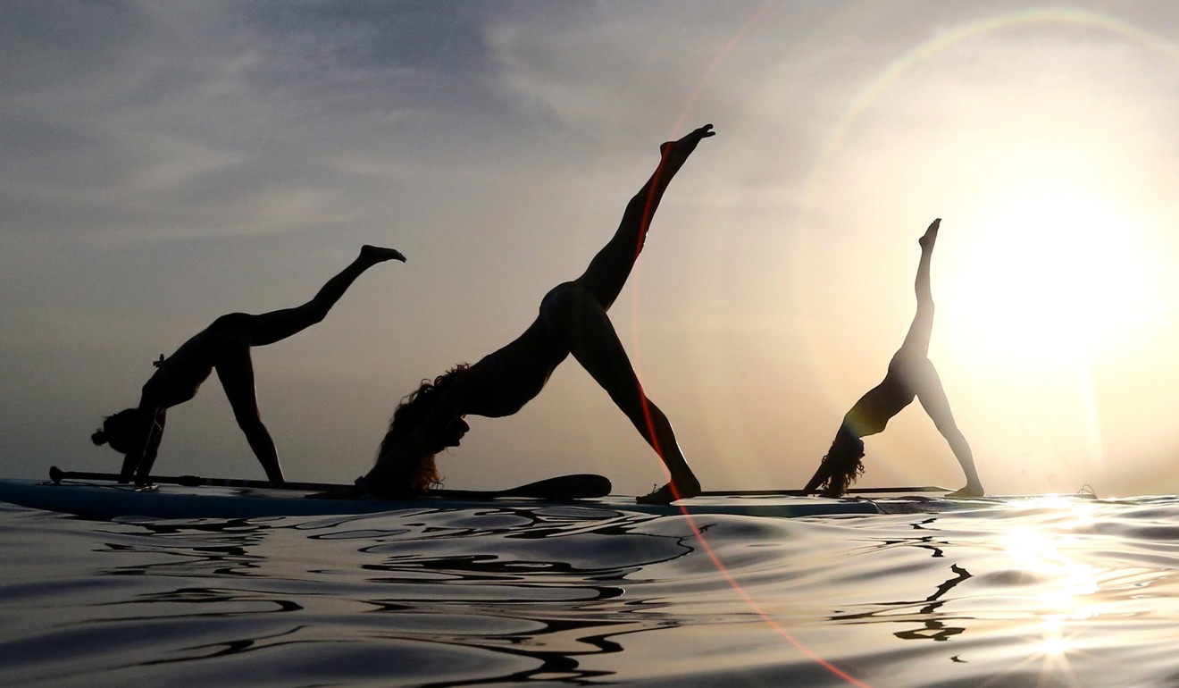 Conentrated women in sportswear practicing yoga in a group, meditating with  arms interlaced in a big studio. Focus on a girl with big shoulder tattoo  Stock Photo - Alamy