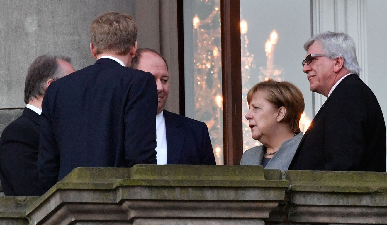 German Chancellor Angela Merkel huddles with other officials on talks to form a new German government. Photo: Agence France-Presse