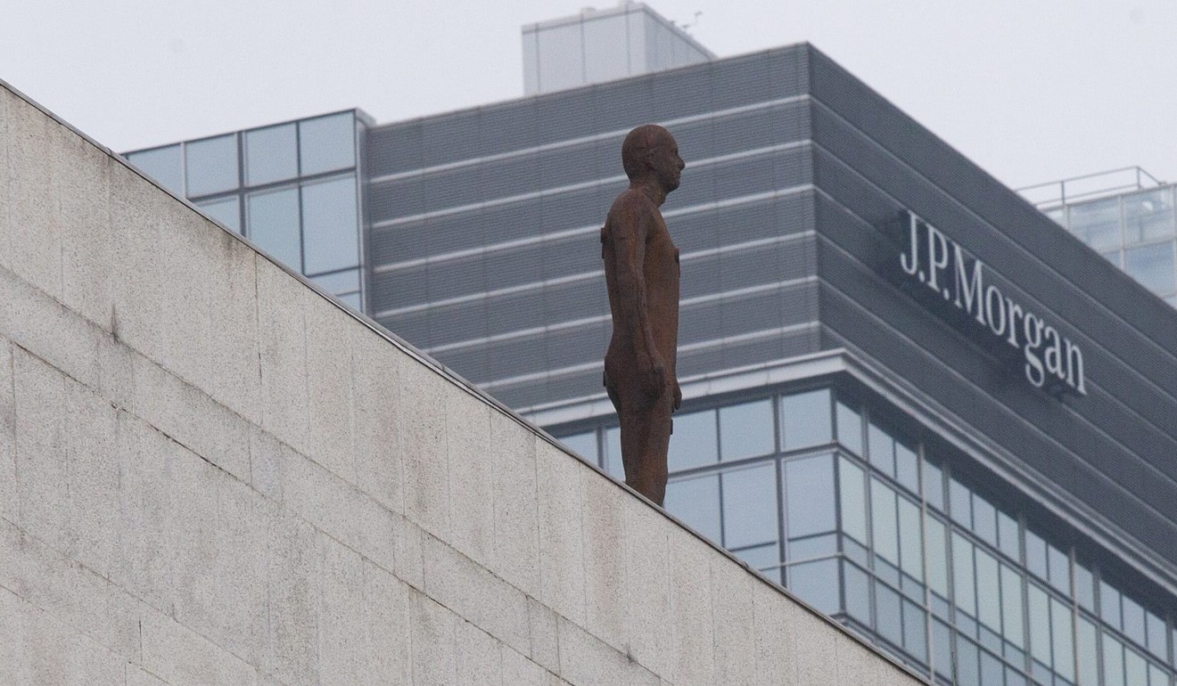 A sculpture of a lone figure by British artist Antony Gormley stands on a rooftop ledge of a building in Hong Kong's financial district, in Central Hong Kong. Photo: EPA