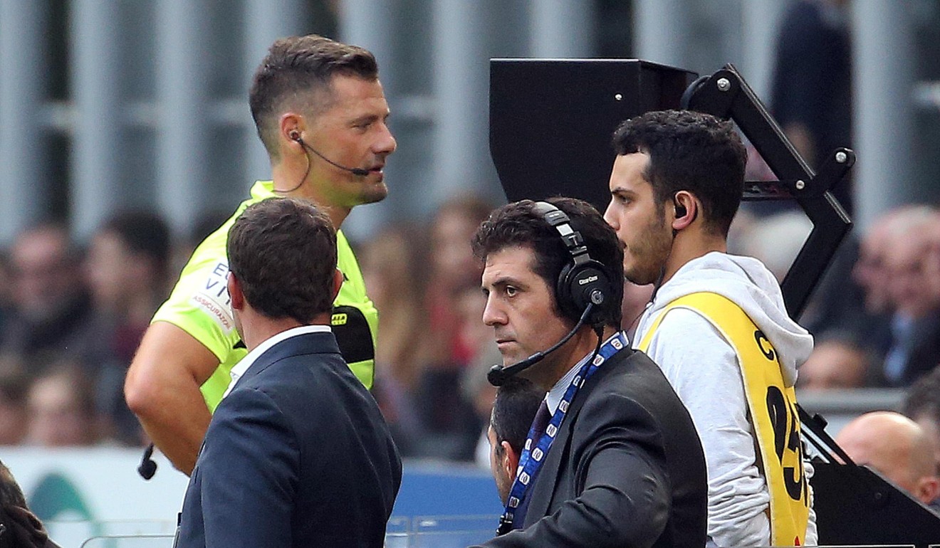 Referee Piero Giacomelli looks at a replay of the video assistant referee (VAR) during the Italian Serie A match between AC Milan and Genoa. Photo: EPA