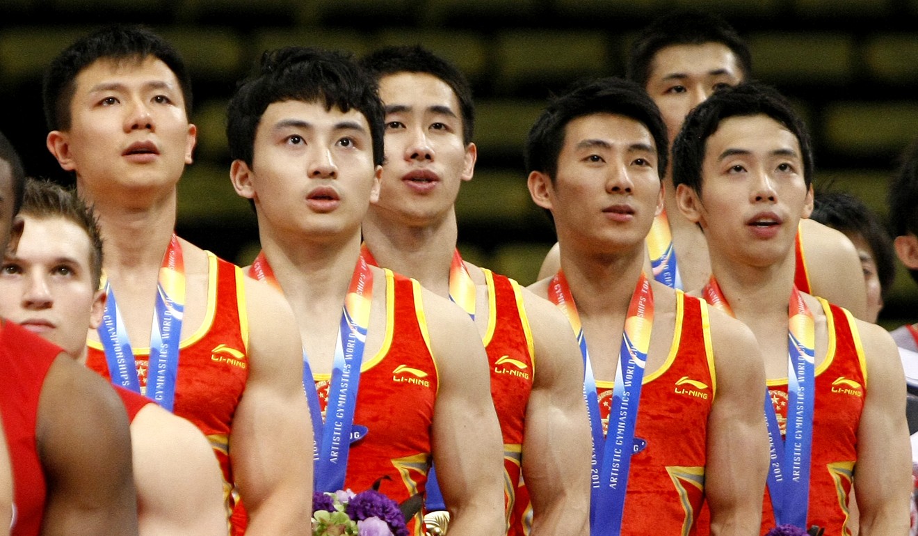 Chinese gymnasts listening to their national anthem. Photo: AP
