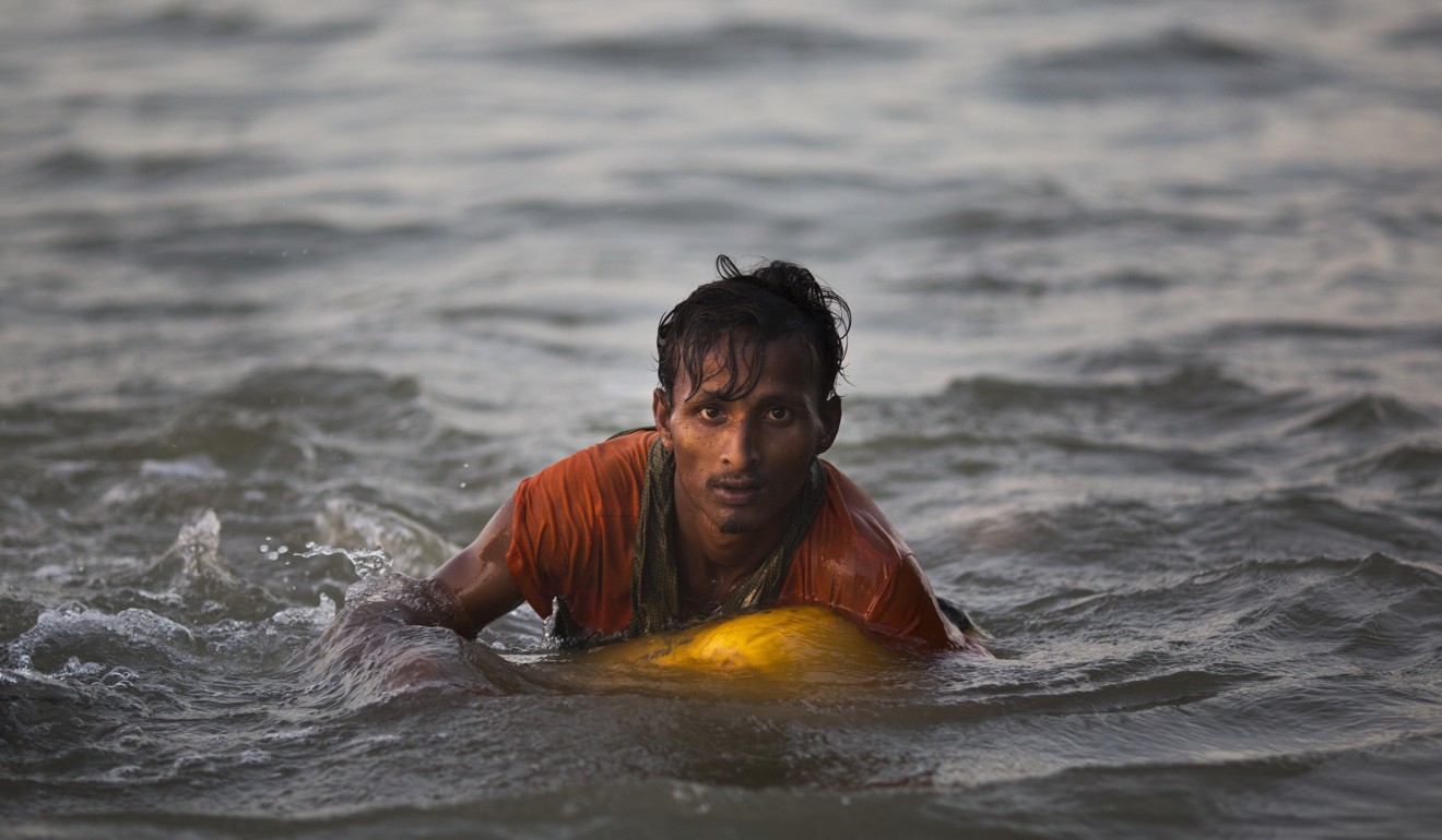 Rohingya Muslim boys use cooking oil drums to cross the Naf river from Myanmar into Bangladesh, escaping a crackdown by the Myanmar military. Photo: AP