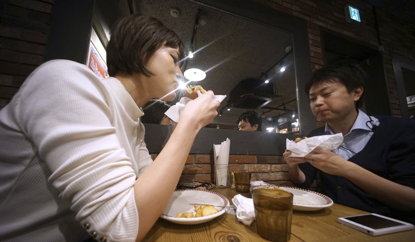 Customers enjoy their burgers at Munch's Burger Shack restaurant in Tokyo. Photo: AP